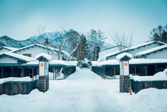 A winter inn with mountains rising behind it at Hoshino Resorts KAI Alps, Omachi, Nagano, Japan